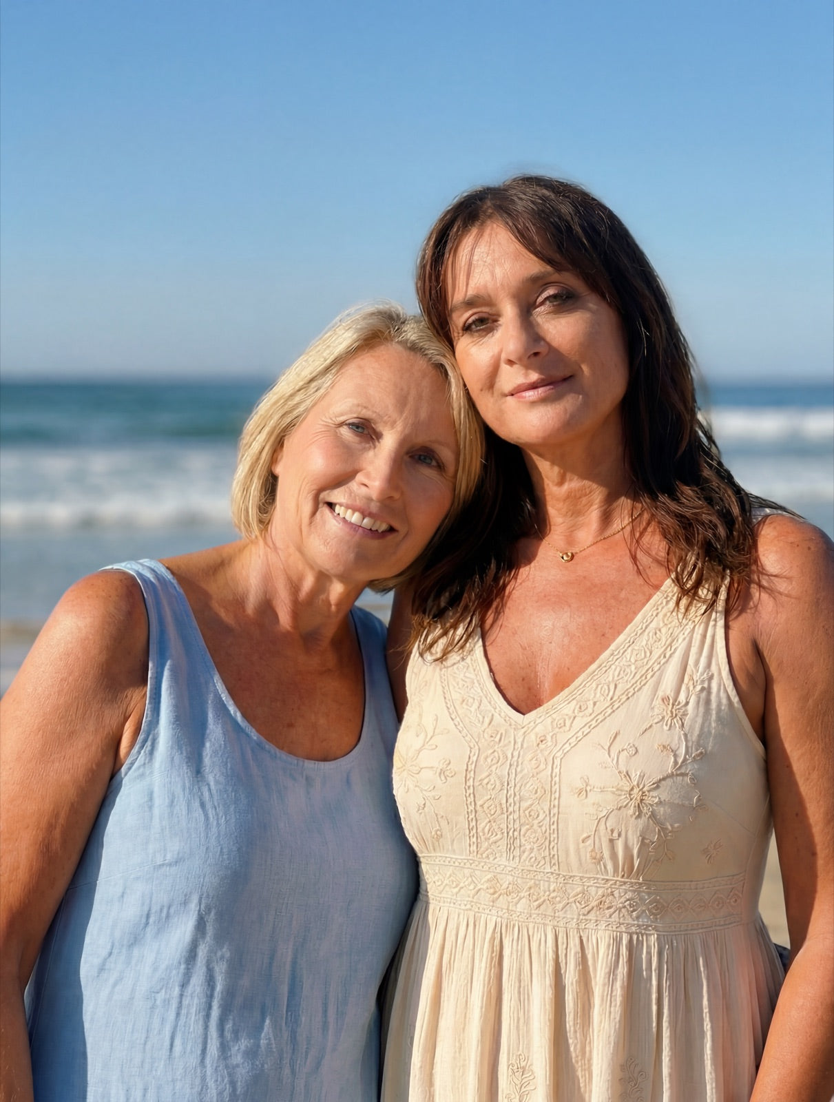Two women standing together beside the ocean